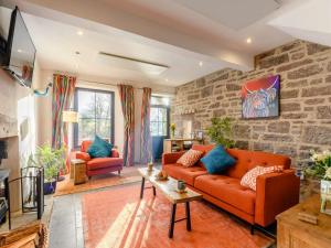 a living room with an orange couch and a brick wall at 1 Bed in Loch Lomond 91056 