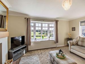 a living room with a couch and a tv and a window at 3 Bed in Cockermouth 90920 in Tallentire