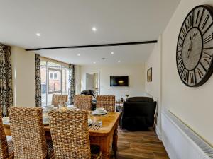 a dining room with a table and chairs and a clock on the wall at 2 Bed in Skendleby Psalter 91139 in Skendleby