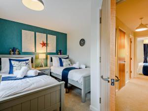 a bedroom with two beds and a green wall at 3 Bed in Lulworth Cove 91200 in West Lulworth