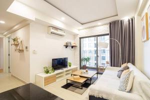 een woonkamer met een bank en een tv bij Nice Masteri ThaoDien apt near Landmark 81 2brs in Ho Chi Minh-stad