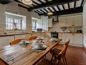 uma grande cozinha com uma mesa de madeira e cadeiras em 2 Bed in Llanover 91242 em Abergavenny