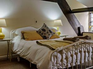 um quarto com uma cama com lençóis brancos e almofadas em 2 Bed in Llanover 91242 em Abergavenny