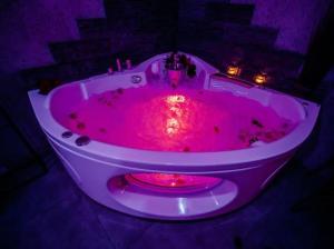 凱爾採的住宿－APARTAMENT NEON JACUZZI W RYNKU KIELCE z Parkingiem-Możliwosć wyżywienia，粉红色的浴缸,有红光