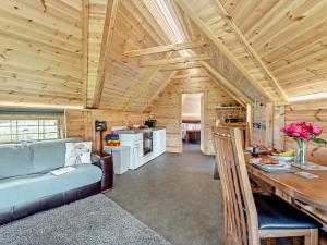 1 Bed in Biggar 91249 في Libberton: غرفة معيشة ومطبخ في كابينة خشب