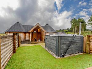 a wooden house with a fence and a yard at 1 Bed in Biggar 91249 in Libberton