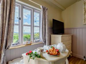 a room with a table with a plate of food and a window at 1 Bed in Boscastle 90818 in Camelford