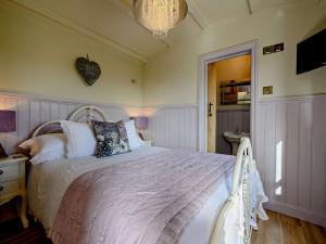 a bedroom with a large bed and a chandelier at 1 Bed in Boscastle 90818 in Camelford