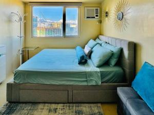 伊洛伊洛* *C2 Simple and Affordable的卧室内的一张床位,配有沙发和窗户