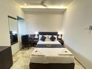 um quarto com uma cama, uma secretária e uma mesa em MIG SUITES em Mumbai