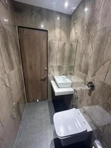 a bathroom with a sink and a toilet at MIG SUITES in Mumbai