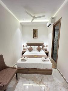 um quarto com uma cama e uma cadeira em MIG SUITES em Mumbai