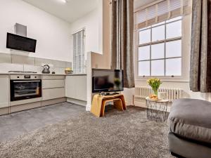 a living room with a television and a kitchen at 1 Bed in Allonby 91113 in Allonby