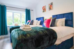 1 dormitorio con 2 camas individuales y cortinas azules en Stylish 3-Bed Home near Anfield with Parking en Walton on the Hill