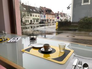 a tray with a cup of coffee on a table at Lèvres Hotel in Schrobenhausen