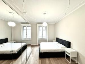 een slaapkamer met 2 bedden en een spiegel bij ComeCasa Fashion apartment Mantova in Milaan