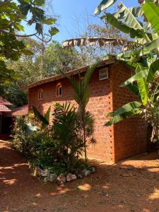 a brick building with a palm tree in front of it at Moradia dos Quadros in Divar