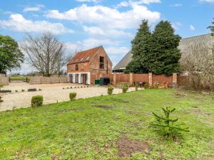 an old brick barn with a yard in front of it at 2 Bed in Reedham 90882 in Cantley