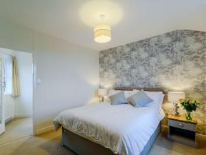 a bedroom with a bed with a floral accent wall at 1 Bed in Holmfirth 91106 in Cartworth