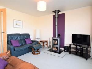 a living room with a blue couch and a fireplace at 2 Bed in New Romney 91126 in Greatstone