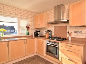 a kitchen with wooden cabinets and a stove top oven at 2 Bed in New Romney 91126 in Greatstone