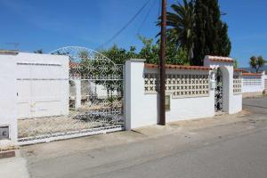 a white fence with a gate on a street at Jouvacations Villa Noguera in Empuriabrava