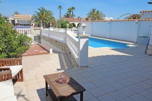 a patio with a table and a swimming pool at Jouvacations Villa Noguera in Empuriabrava