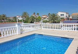 a swimming pool next to a white fence at Jouvacations Villa Noguera in Empuriabrava