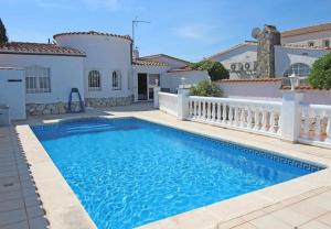 a swimming pool in front of a house at Jouvacations Villa Noguera in Empuriabrava +39 photos