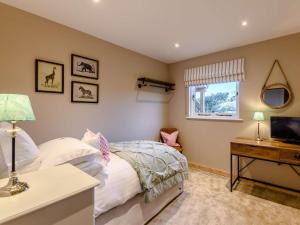 Finghall的住宿－2 Bed in Leyburn 91102，一间卧室配有一张床、一张书桌和一台电视