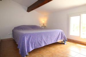 um quarto com uma cama com um edredão roxo em GASREM - Golfe de St-Tropez - Mazet dans domaine avec piscine et tennis em Gassin