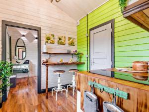 a kitchen with green walls and a counter with chairs at 1 Bed in Malvern 91025 in Castlemorton