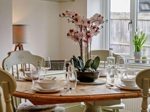 een eettafel met glazen en bloemen erop bij 3 Bed in Gilwern 91181 in Gilwern