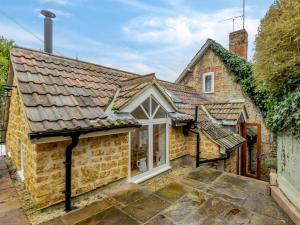 a stone cottage with white windows and a roof at 1 Bed in Castle Cary 91185 in Castle Cary