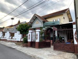 a house with a gate on a street at Zzz Ijen Hostel in Banyuwangi