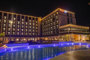 a hotel with a swimming pool in front of a building at Argyle Grand Hotel Nairobi Airport in Nairobi