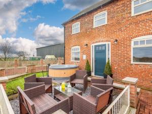 a patio with chairs and a table and a hot tub at 2 Bed in Caunton 91051 in Caunton