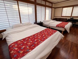 um quarto com três camas num quarto com janelas em Hondori Inn em Hiroshima