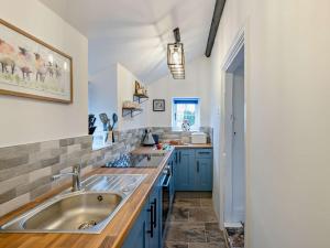 a kitchen with a sink and blue cabinets at 1 Bed in Llangollen 91040 in Llangollen