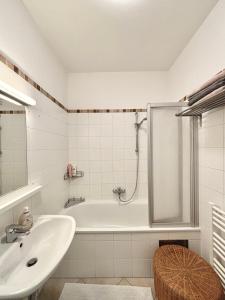 uma casa de banho branca com uma banheira e um lavatório em Good Old Times Apt II em Viena