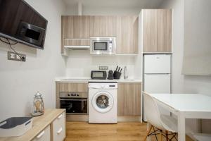 a kitchen with a washing machine and a microwave at Ideal flat in the Retiro area - C5 in Madrid