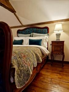a bedroom with a bed and a lamp and a table at Historic cottage with oak beams & period charm in Llangadog