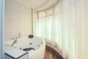 a white bath tub in a room with a window at Eldon Suites & Apartments in Nairobi