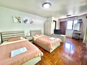 1 dormitorio con 2 camas y TV. en เรือนกิ่งไผ่ (กรรณิการ์ แพร่ โฮมสเตย์), en Ban Kha Ngam