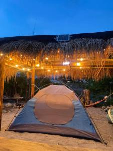 ein Zelt am Strand mit einem Strohdach in der Unterkunft Campayapa in Botolan