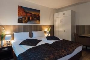 a bedroom with a large bed with two pillows at Hotel Hanseat Hamburg in Hamburg