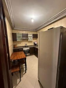 a small kitchen with a table and a refrigerator at Holikeys - El Jadida - 2 Ch - Sidi Bouzid 004 in El Jadida