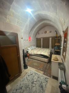 Habitación pequeña con cama y puerta en Yeşilöz inn Cave otel en Urgup