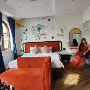 a woman is standing next to a bed in a room at LITTLE PHU QUOC STUDIO in Phu Quoc