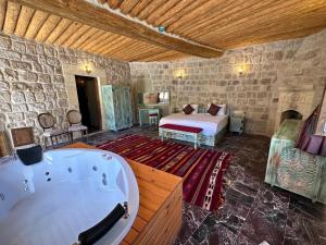 a bedroom with a tub and a bed in a room at Doctor's Cave Cappadocia in Urgup